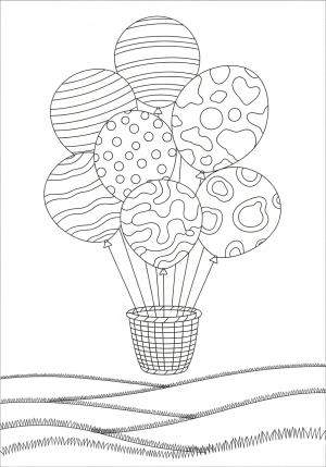 An array of different patterned balloons tethered to a basket, floating above a grassy field.